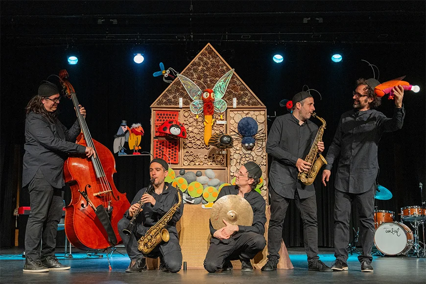 Cinc musics tocant amb antenes d'insecte al cap.