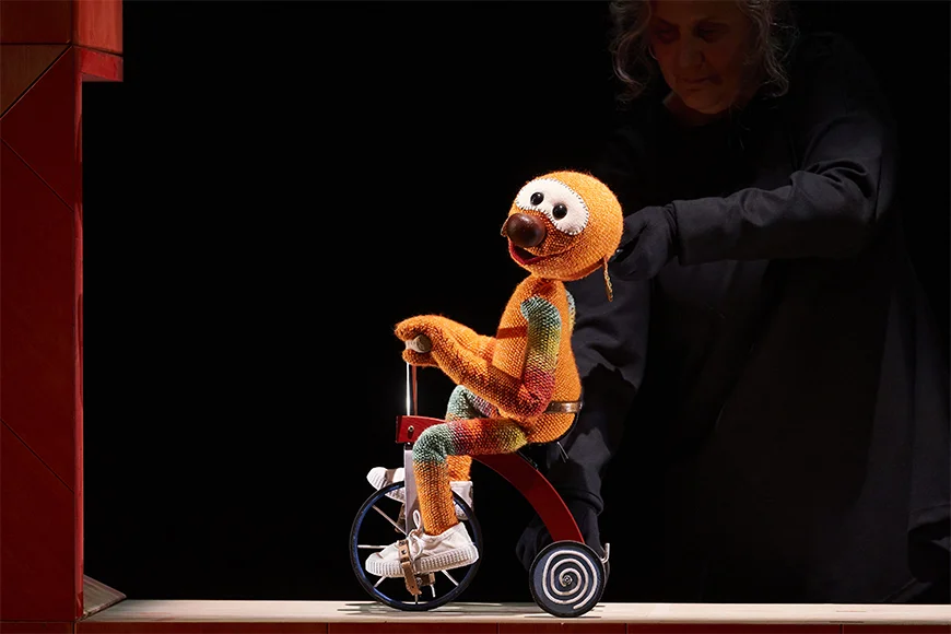Escena de l'espectacle on es veu el titella Mic amb el seu tricicle.
