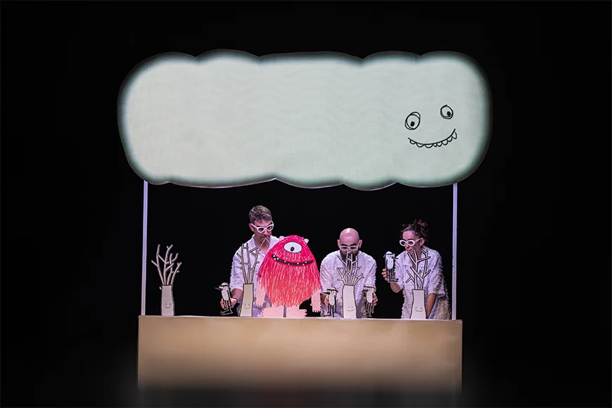 Tres actors manipulen una escenografia de paper i el Monstre Rosa.