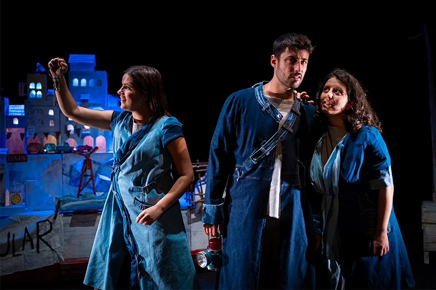 Escena de l’espectacle en què es veuen els tres personatges drets, mig abraçats.