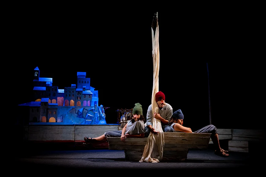 Escena de l'espectacle on es veuen els tres personatges en una barca.