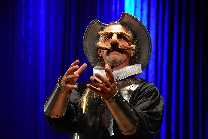 El Quixot amb un nas i uns bigotis postissos amb un posat seriós.